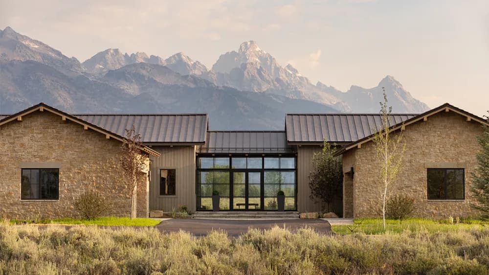 A gated luxury estate framed by mature landscaping in a premium market